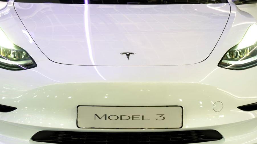 A white Tesla Model 3 luxury compact electric sedan model at the 100th edition of the Brussels Motor Show