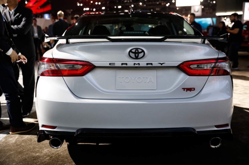 A white Toyota Camry, one of the most reliable used cars for the money, parked in an indoor area.