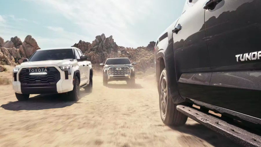 A trio of 2023 Toyota Tundra trucks drive through the desert.