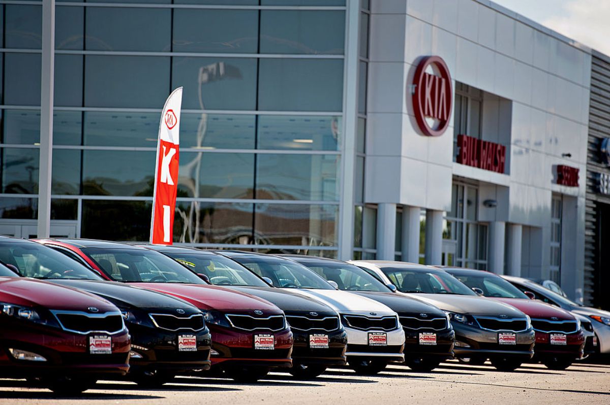 Kia cars lined up on display at a dealership.