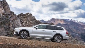 Side view of a Volvo V60 Cross Country driving off-road in the mountains.