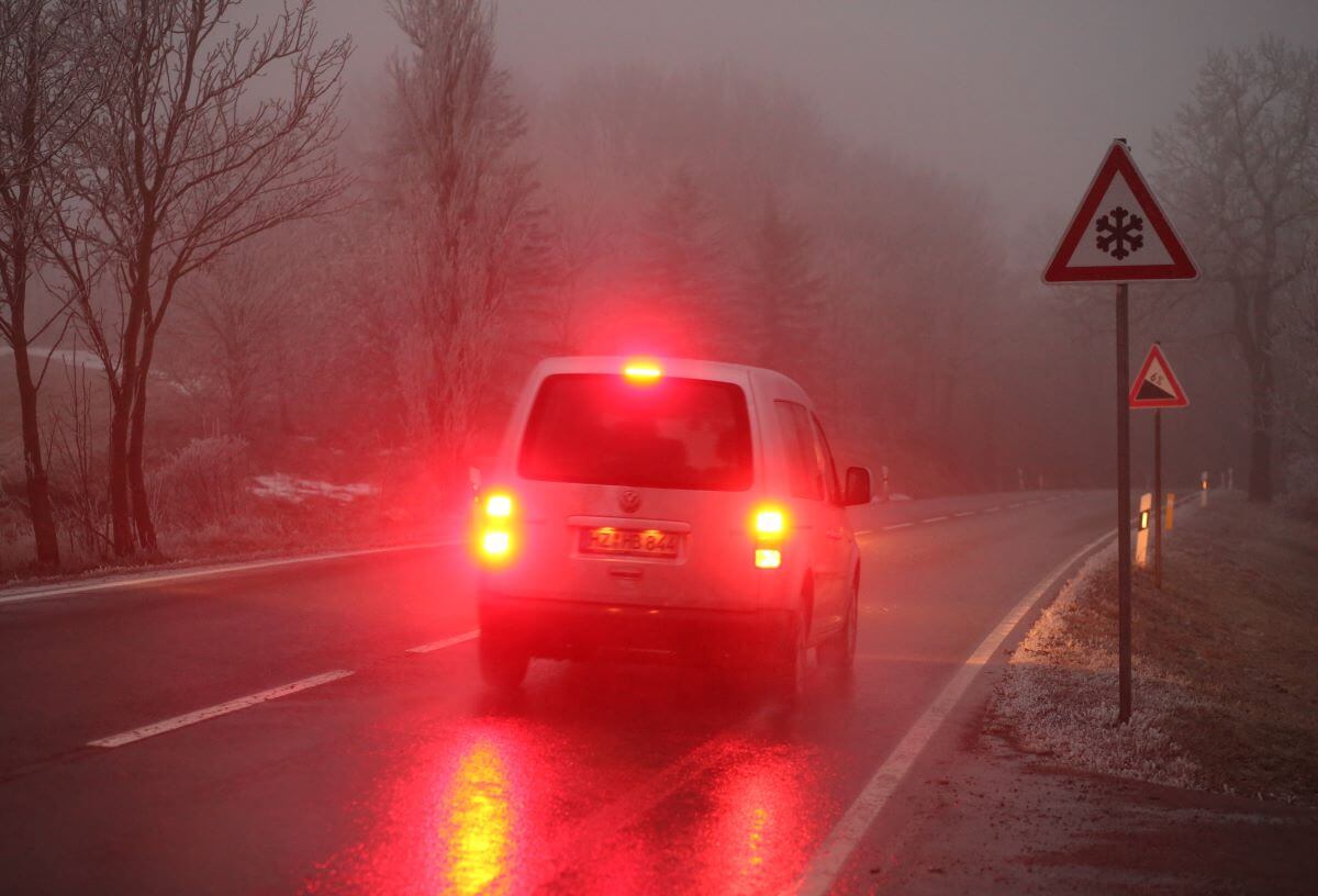 Brake lights of a Volkswagen vehicle lit up in a winter fog in the Harz Mountains of Saxony-Anhalt, Elbingerode