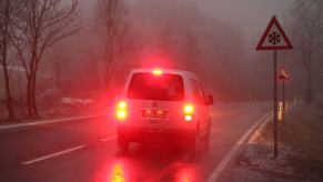 Brake lights of a Volkswagen vehicle lit up in a winter fog in the Harz Mountains of Saxony-Anhalt, Elbingerode