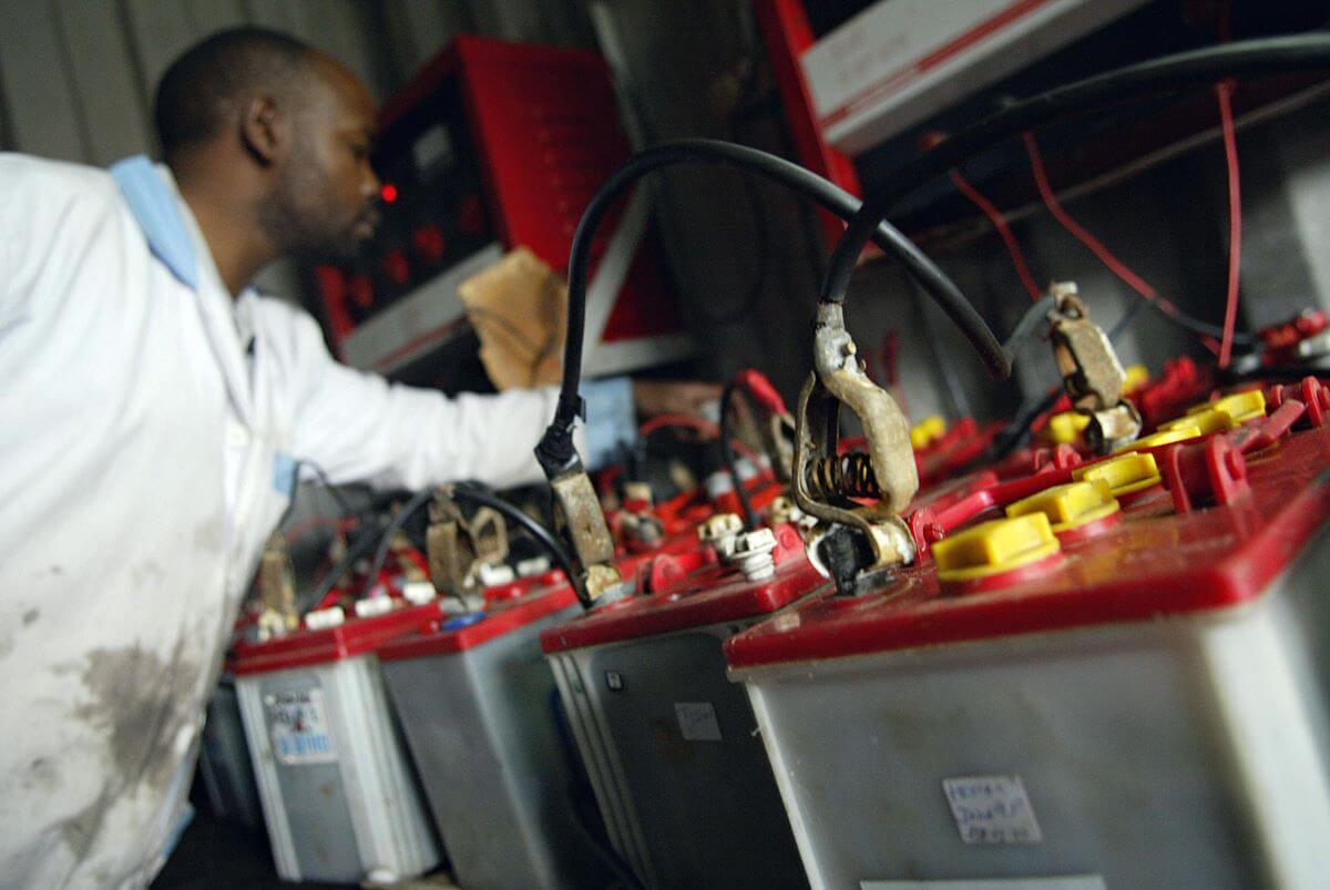 Old car batteries being recharged and recycled for components at a second-hand battery shop in Nairobi, Kenya