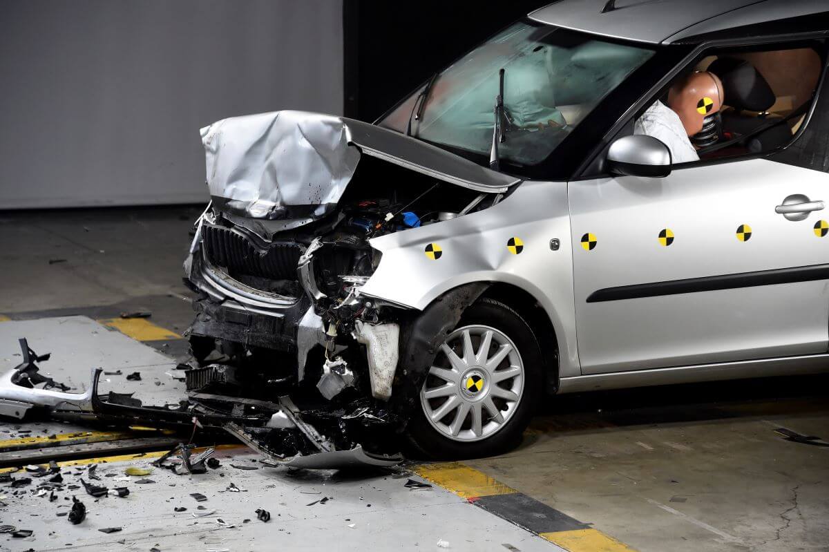 A frontal crash test with another vehicle with crash test dummies not wearing seat belts in Paris, France
