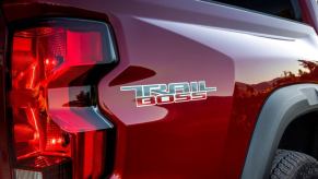 A red 2023 Chevy Colorado midsize pickup truck model with Trail Boss markings on the vehicle's bed
