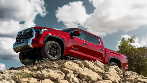 A red 2023 Toyota Tundra Unlimited full-size pickup truck model parked on a hill of dirt and stones