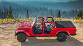 The removable convertible top roof on a 2023 Jeep Gladiator Rubicon midsize pickup truck model on a forest hill