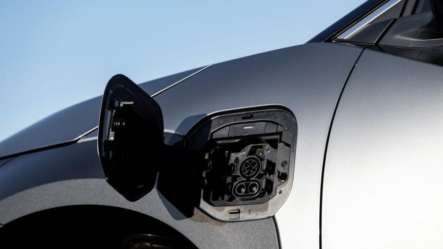 The open charging port on a silver-gray 2023 Toyota bZ4X electric compact SUV model