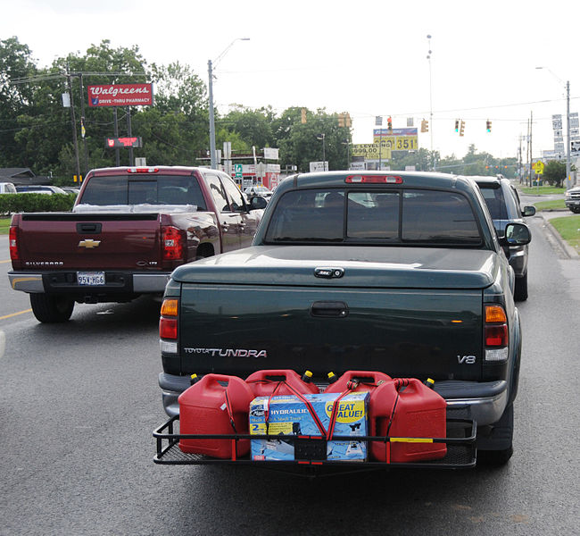 a black truck transporting gas cans on the back bumper