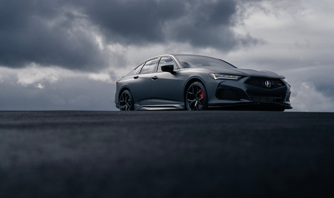 The 2023 Acura TLX Gotham Gray Edition parked with stormy clouds in the background