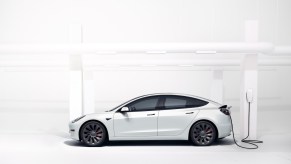 White Tesla Model 3 plugged in to charge