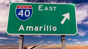 A sign for I-40 east towards Amarillo Texas via the interstate highway system, a blue sky visible in the background.