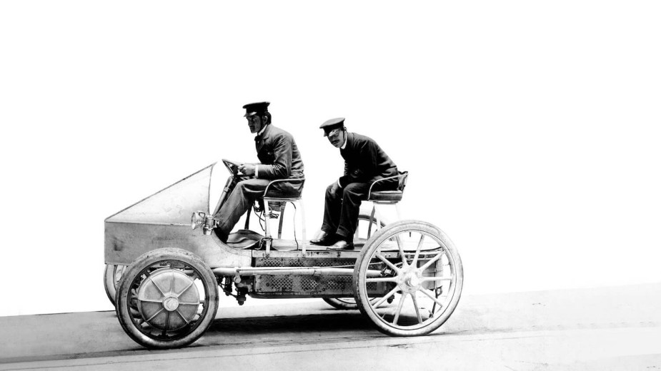 Two men ride on Ferdinand Porsche's 1899 EV hybrid vehicle.