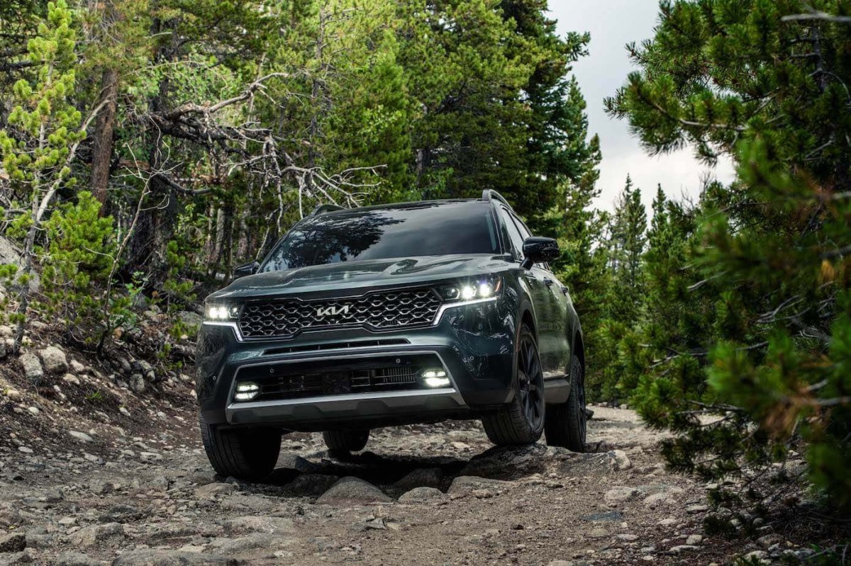 The front of a gray 2023 Kia Sorento X-Line going off-roading in the forest.