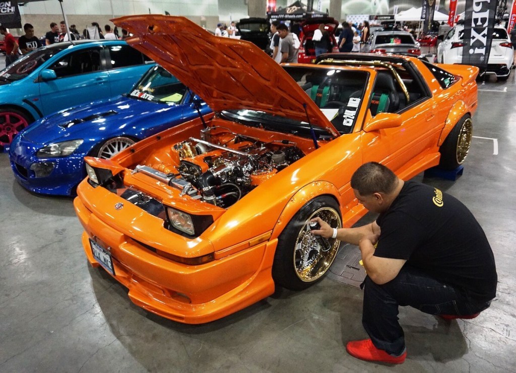 An orange 1988 Toyota Supra parked at a car show