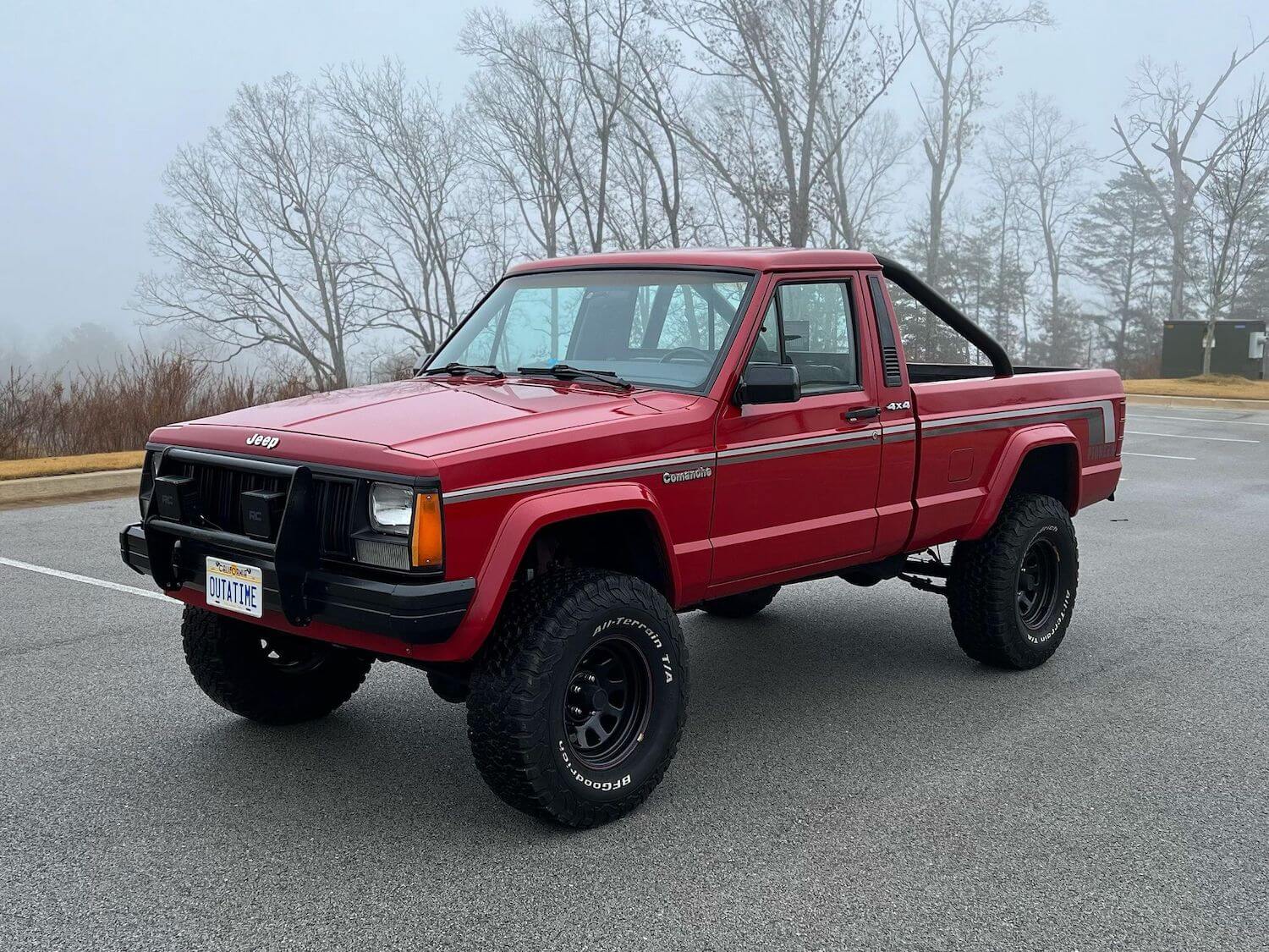 The front of a used Jeep Comanche classic truck fitted with a lift kit and rollbar.