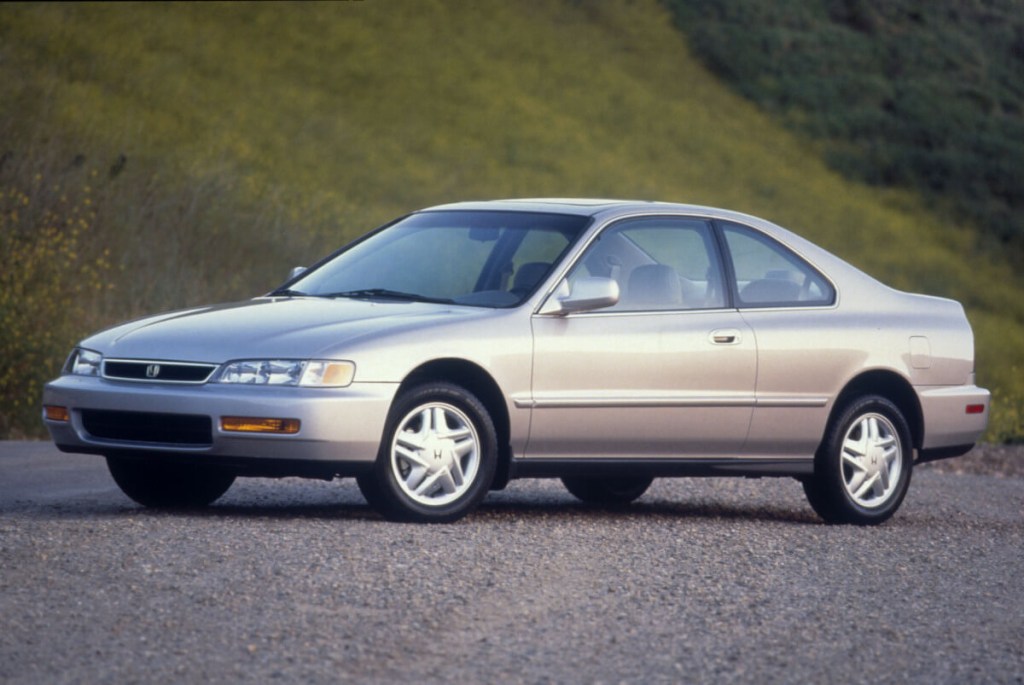 A 1997 Honda Accord, the understated car of Jeff Bezos, parks next to a grassy hill. 