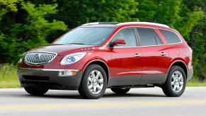 A red 2008 Buick Enclave driving on a highway.