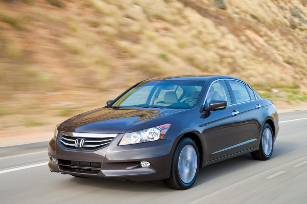 A used Gray 2008 to 2011 Honda Accord cruises a mountain road. 