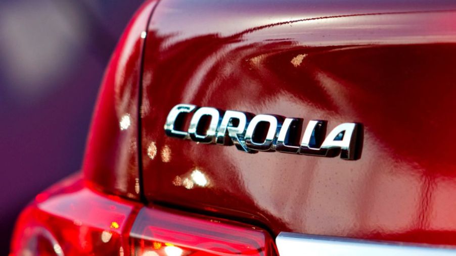 A close up view of a Toyota Corolla nameplate on a red 2011 model.