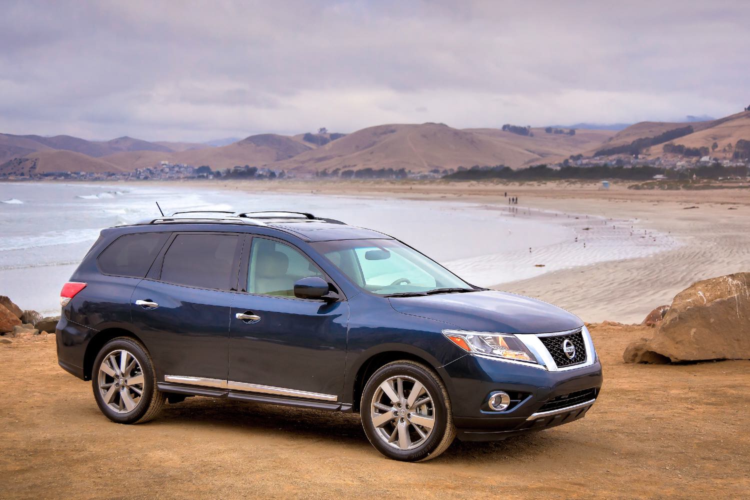 A blue 2014 Nissan Pathfinder on the beach. This SUV has serious transmission problems