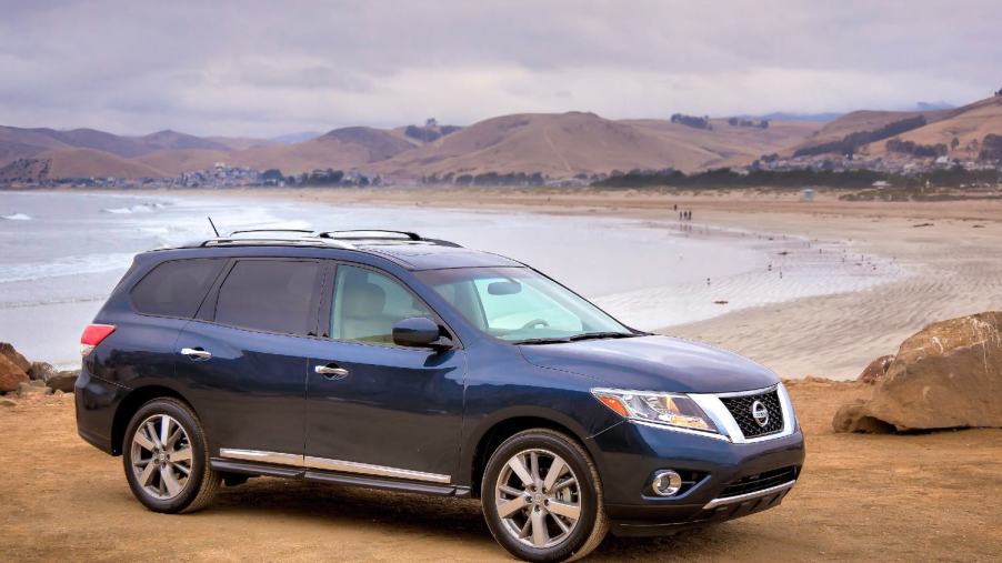 A blue 2014 Nissan Pathfinder on the beach. This SUV has serious transmission problems