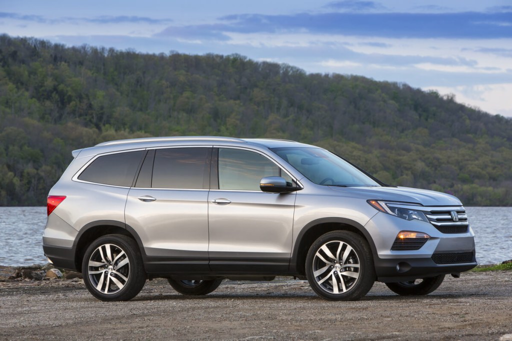 A 2016 Honda Pilot SUV parks next to a lake.