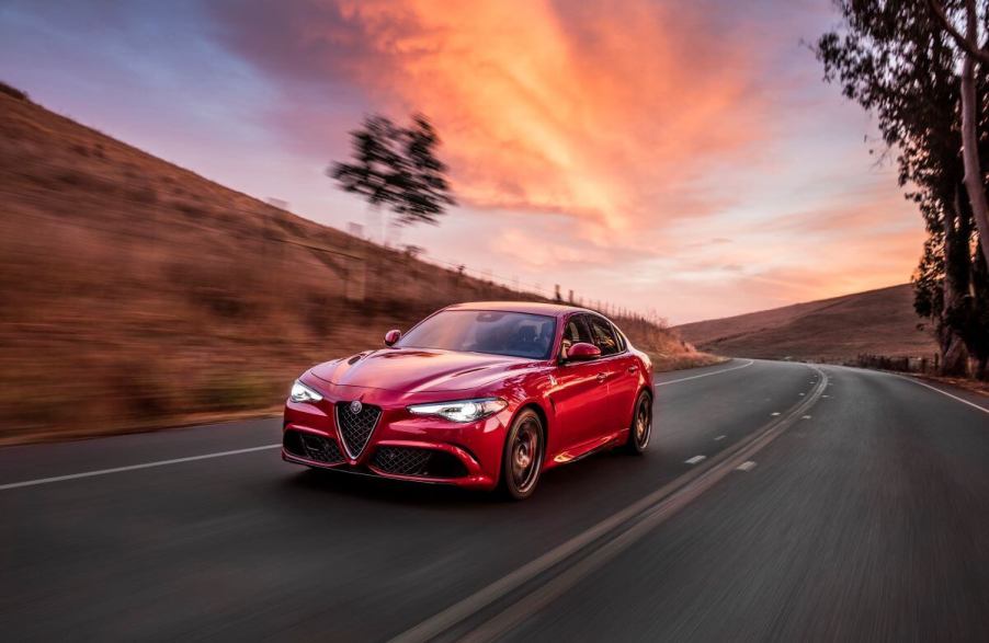 A red 2017 Alfa Romeo Giulia Quadrifoglio executive car model driving under a cloudy red sky