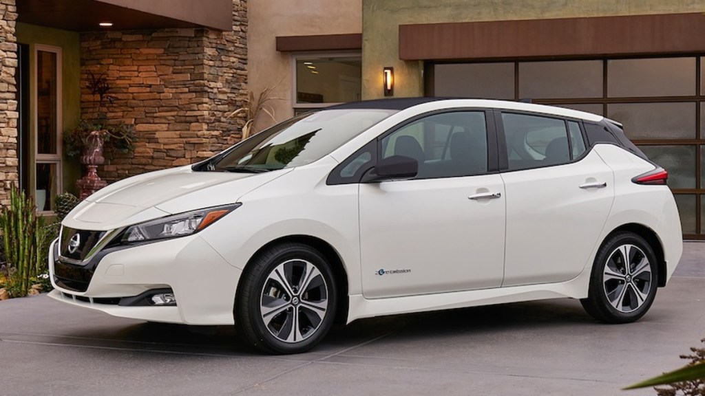 White 2018 Nissan Leaf EV parked in front of a house