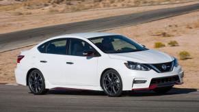 A white 2018 Nissan Sentra NISMO compact sedan model with a performance style package on a desert road