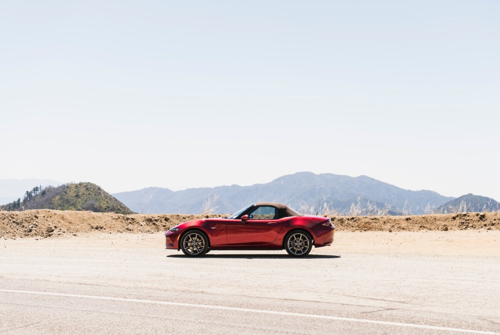 A red 2023 Mazda MX-5 Miata parked in the desert