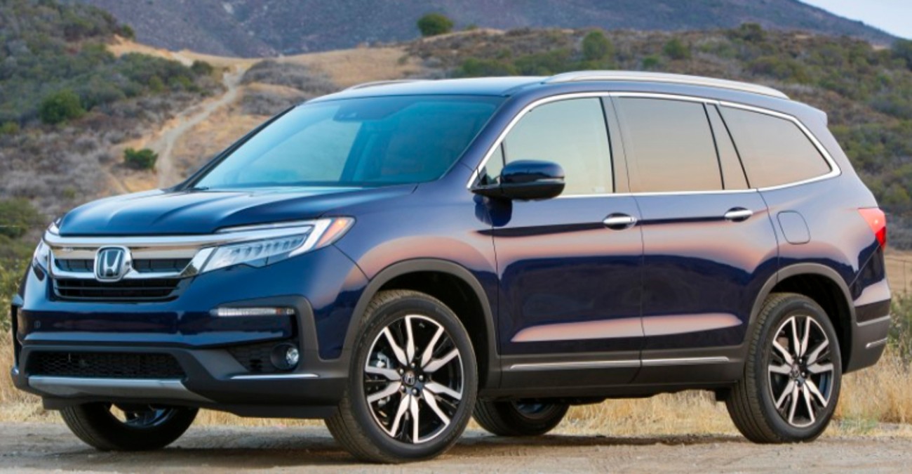 Blue 2020 Honda Pilot SUV parked in front of a grassy hill