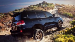 A blue Toyota Land Cruiser full-size SUV is driving off-road.