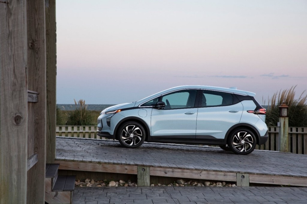 A blue 2022 Chevrolet Bolt electric vehicle parks on an incline.