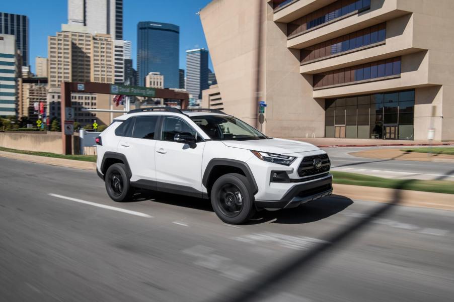 A white 2023 Toyota RAV4 TRD Off-Road driving on a city road