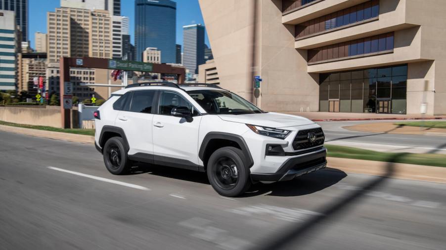 A white 2023 Toyota RAV4 TRD Off-Road driving on a city road