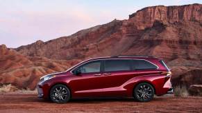 A red Toyota Sienna parked in front of a canyon.