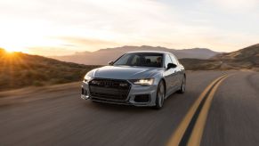 A gray 2023 Audi S6 driving down an open road.
