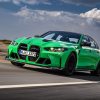 A green BMW M3 four-door, which compares to the BMW M4 coupe