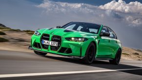 A green BMW M3 four-door, which compares to the BMW M4 coupe