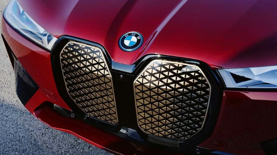 The front of a red 2024 BMW iX midsize electric SUV.