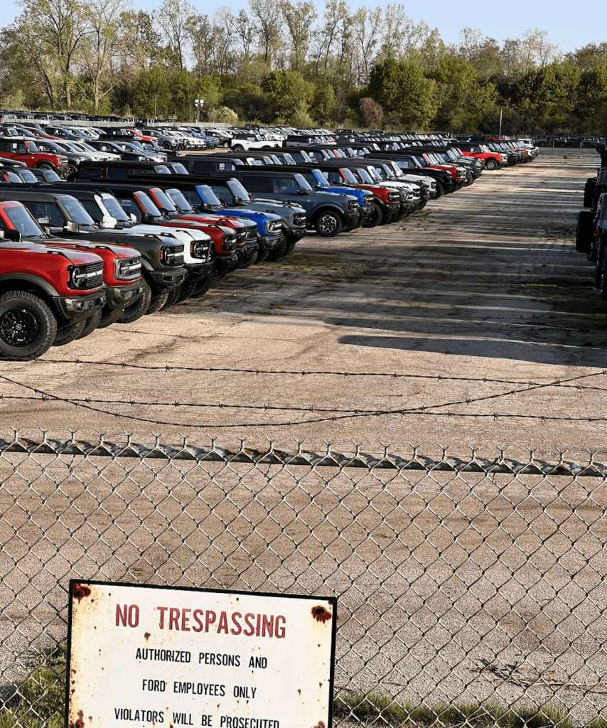 Shot of 2023 Ford Broncos in Ypsilanti holding lot surrounded by trees