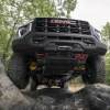 The 2023 GMC Canyon AT4X AEV climbing over rocks