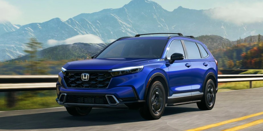 A blue 2023 Honda CR-V small SUV is driving on the road. 