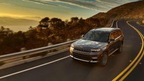 A 2023 Jeep Grand Cherokee L Summit Reserve midsize SUV model driving down a highway
