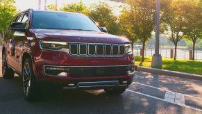 A red 2023 Jeep Wagoneer full-size SUV is driving on the road.