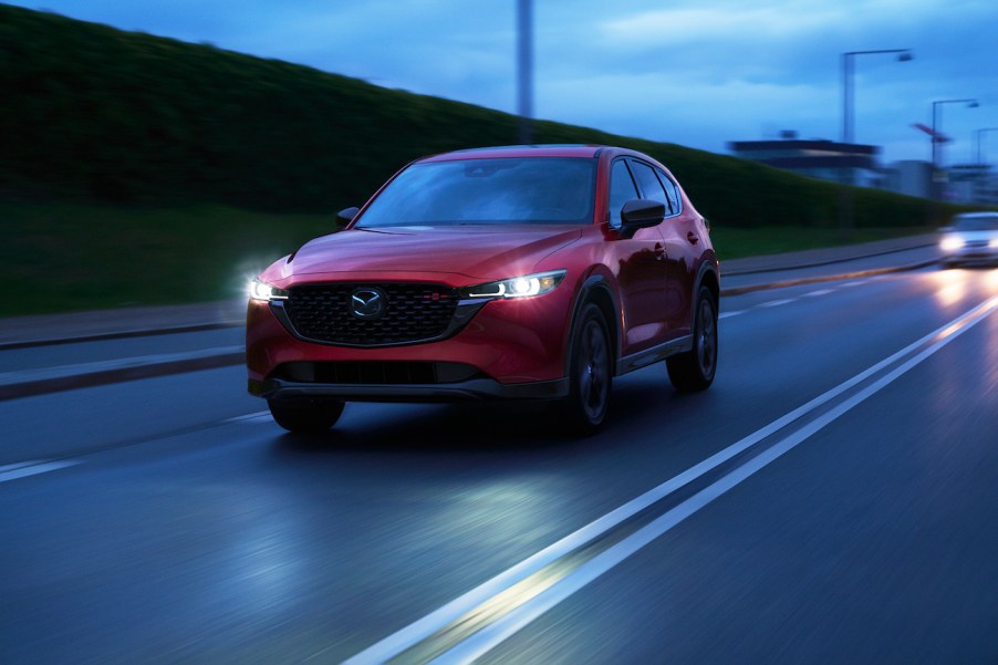 A red 2023 Mazda CX-5 2.5 Turbo on the road in the evening.