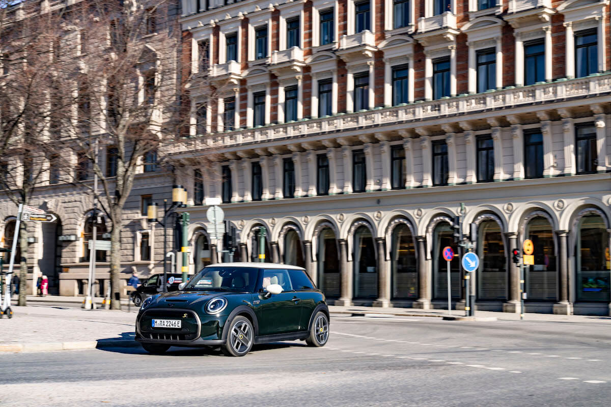 A black 2023 Mini Cooper parked in a small town in Italy