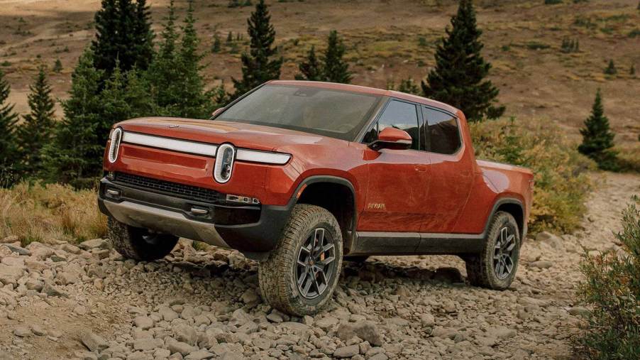 The 2023 Rivian R1T off-roading over rocky terrain